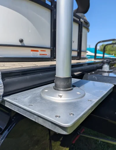 Close-up of aluminum marine mounting bracket with welded base plate attached to boat deck.
