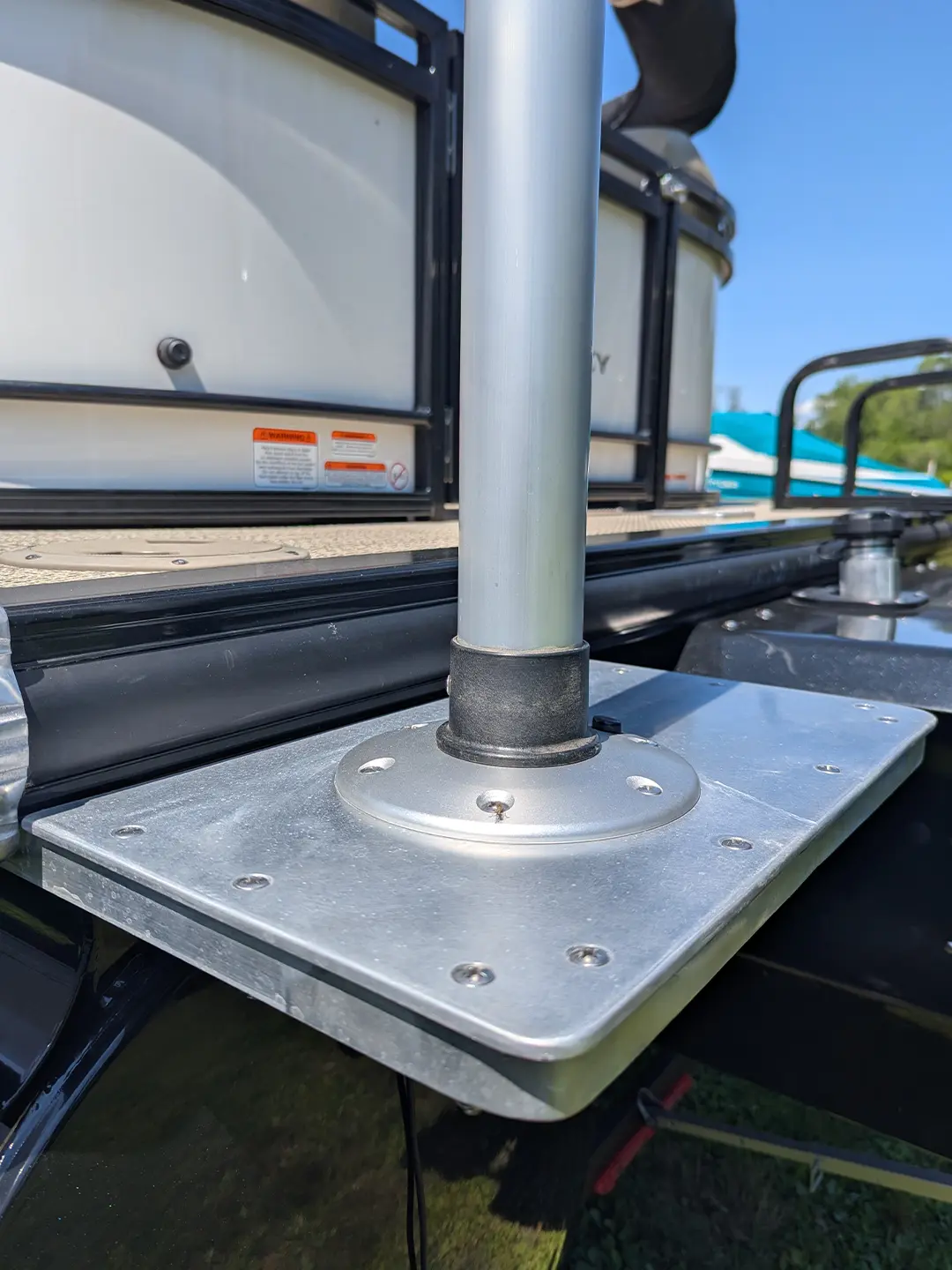 Close-up of aluminum marine mounting bracket with welded base plate attached to boat deck.