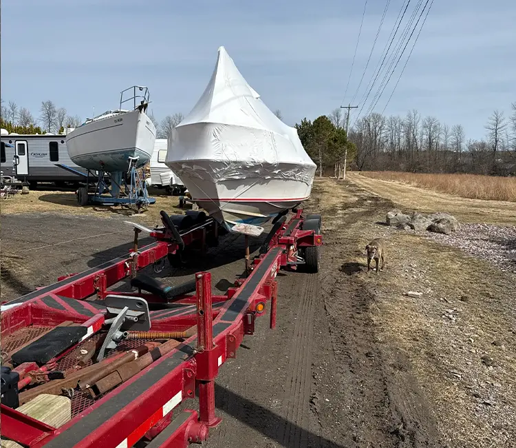 Boat Repair and Hauling services in Vermont with shrink-wrapped boat on hydraulic trailer
