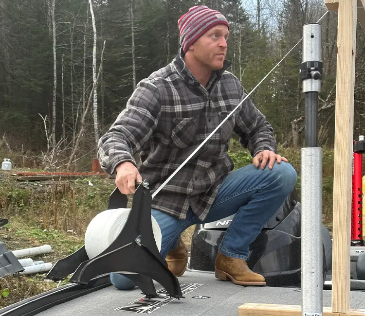 Technician providing on-location boat repair in Vermont, working on boat deck at a lakeside property